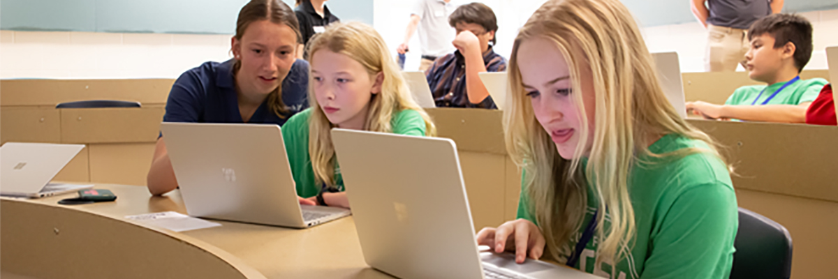 students sitting at laptops learning to code