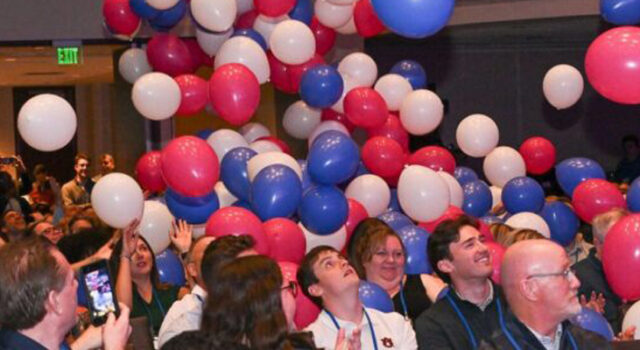 Balloons falling down on people seated in chairs