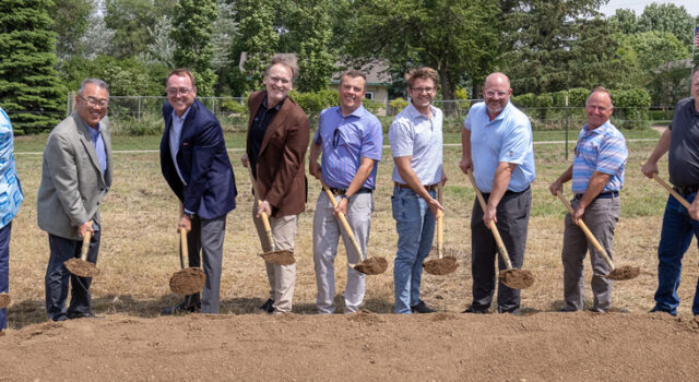 A group of people posed with shovels at the Mapleton Highlands groundbreaking