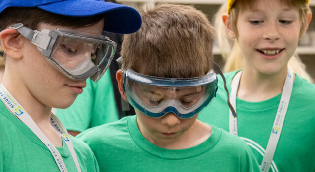 three boys doing a chemistry experiment at Your Future STEM Day Camp 2025