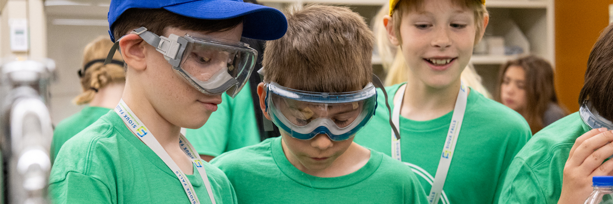three boys doing a chemistry experiment at Your Future STEM Day Camp 2025