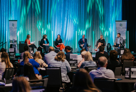 A picture of 6 people on a stage at the WIN in Workforce Summit