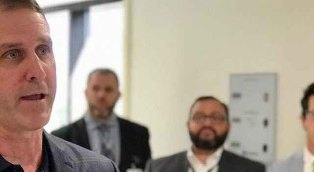 A photo of Dave Flicek speaking in front of a group of people