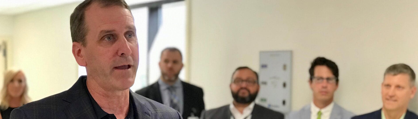 A photo of Dave Flicek speaking in front of a group of people