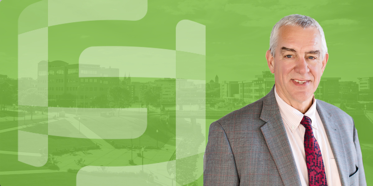 A photo of Bob Mundt with a green overlayed aerial photo of Sioux Falls in the background