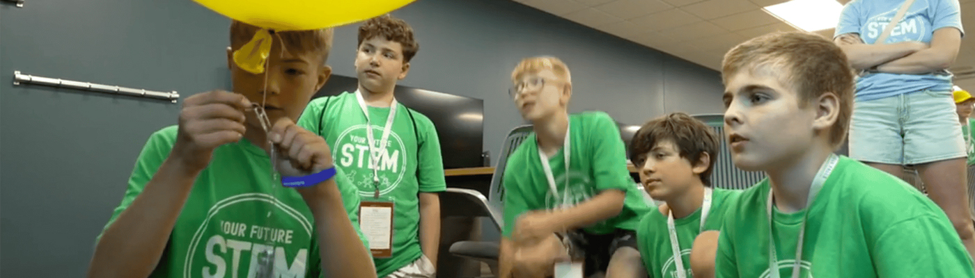 A photo of students doing an activity with balloons and paper clips at Your Future STEM Summer Day Camps 2026