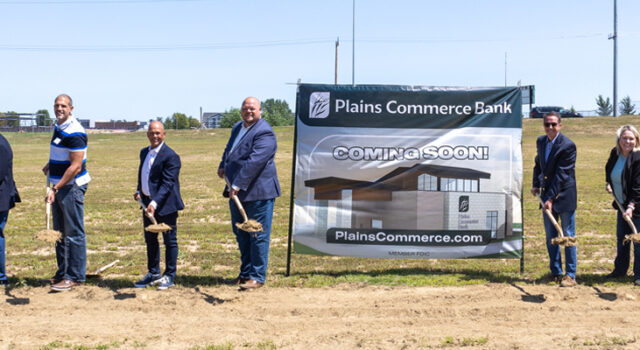 A group of people posing with shovels at the groundbreaking for Plains Commerce Bank