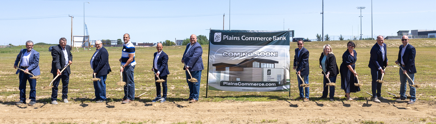 A group of people posing with shovels at the groundbreaking for Plains Commerce Bank